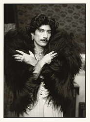 Photograph called Bobo in furs, San Francisco, 1974, of a man with a mustache in a dress and wearing a black fur stole.